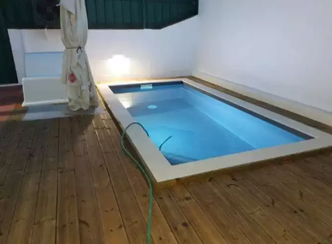 Piscina remodelada com bordo em pedra