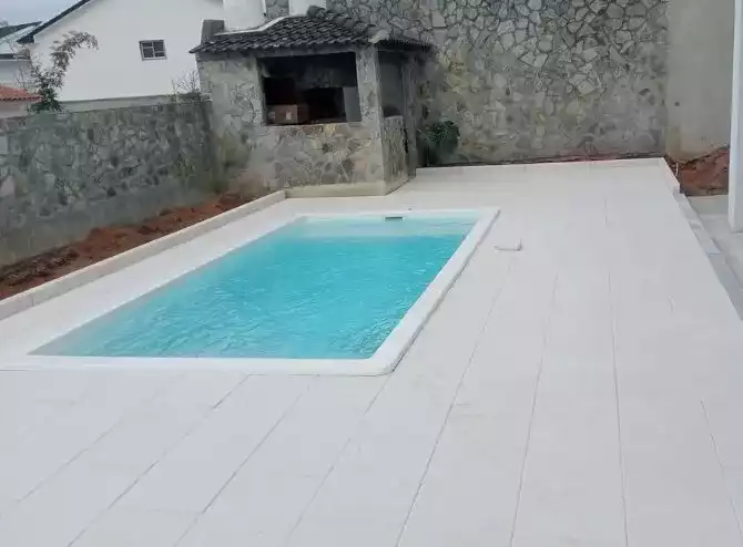 Construção em alvenaria com piscina e parede de pedra natural